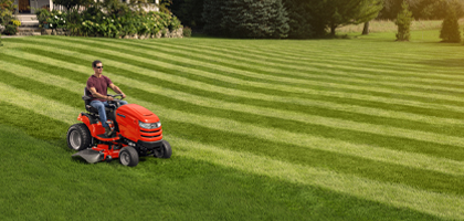Man riding Simplicity tractor on striped lawn