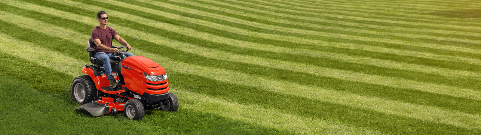 Man riding Simplicity tractor on striped lawn