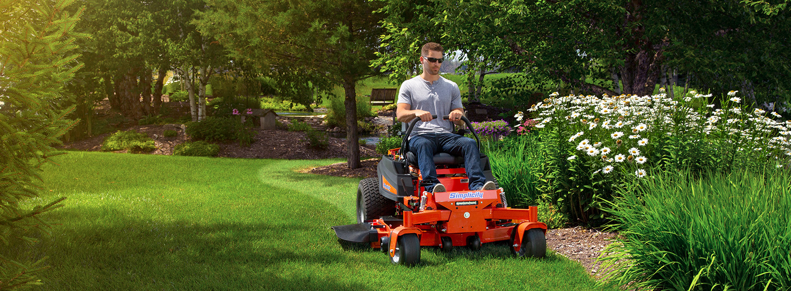 Man riding zero turn mower by landscaping