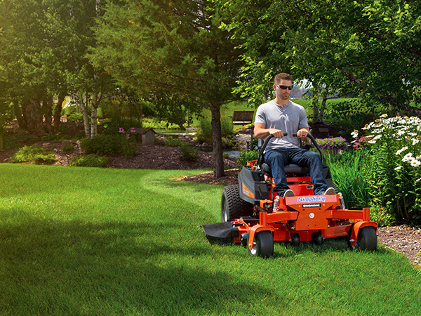 Man riding zero turn mower by landscaping