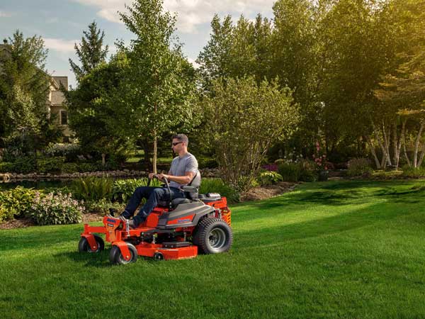 Man using tractor cargo bed for landscaping